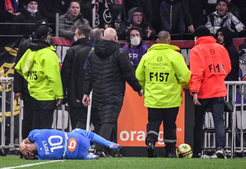 Marseille's French midfielder Dimitri Payet lies on the field injured afte being struck by a water bottle thrown from the crowd. AFP