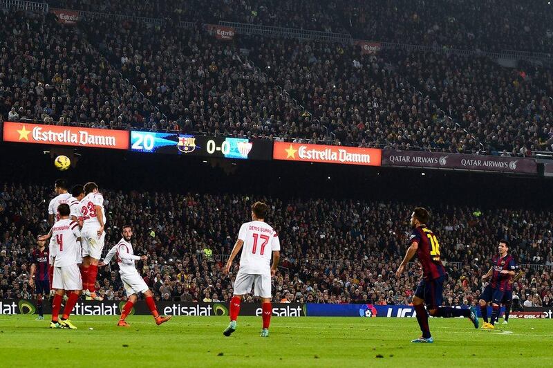 Lionel Messi of Barcelona scores the opening goal on a free kick against Sevilla in La Liga on Saturday night. David Ramos / Getty Images