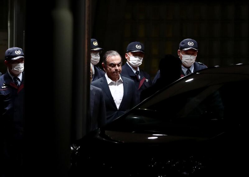 (FILES) In this file photo taken on April 25, 2019 former Nissan chairman Carlos Ghosn (C) is escorted as he walks out of the Tokyo Detention House following his release on bail in Tokyo.

 A year after Japan learned with horror that Carlos Ghosn had jumped bail to become the world's most famous fugitive, the fiasco and its repercussions continue to haunt the country. Ghosn was living in a monitored Tokyo apartment awaiting trial on financial misconduct charges when he casually boarded a train to Osaka in western Japan on December 29, 2019 with two accomplices. - TO GO WITH AFP FOCUS "JAPAN-GHOSN-AUTOMOBILE-LEBANON-NISSAN-RENAULT" BY ETIENNE BALMER 
 / AFP / Behrouz MEHRI / TO GO WITH AFP FOCUS "JAPAN-GHOSN-AUTOMOBILE-LEBANON-NISSAN-RENAULT" BY ETIENNE BALMER 
