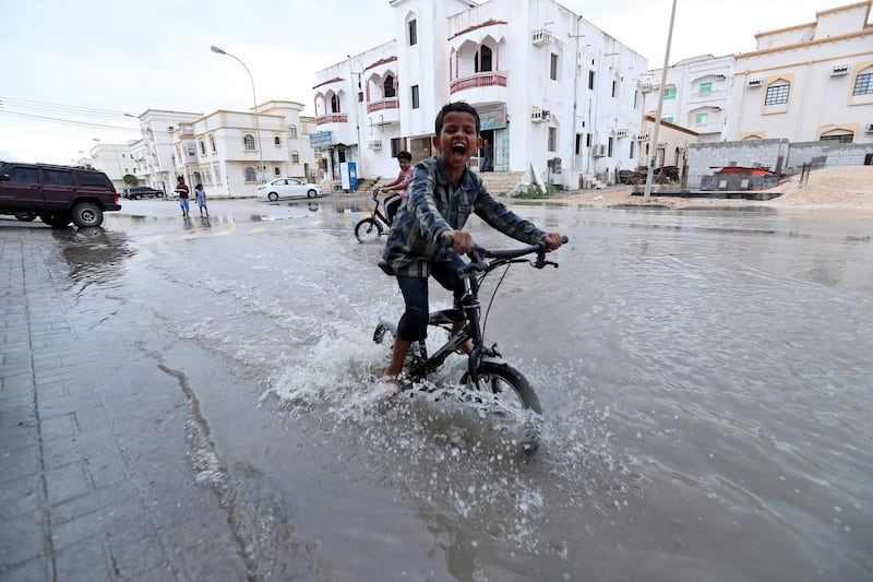 A child plays in a roadside puddle accumulated from rain brought by Cyclone Luban in Salalah, Oman, October 13, 2018. REUTERS/Stringer