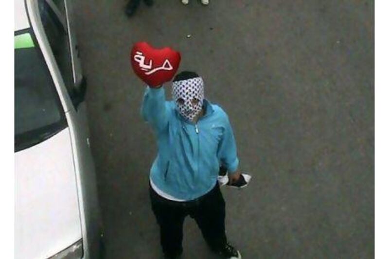 An anti-Assad protester holds up a red heart with Arabic word reading 'the freedom' during a demonstration against the Syrian regime in Homs province, Syria. AP Photo / Homs Quarters Union