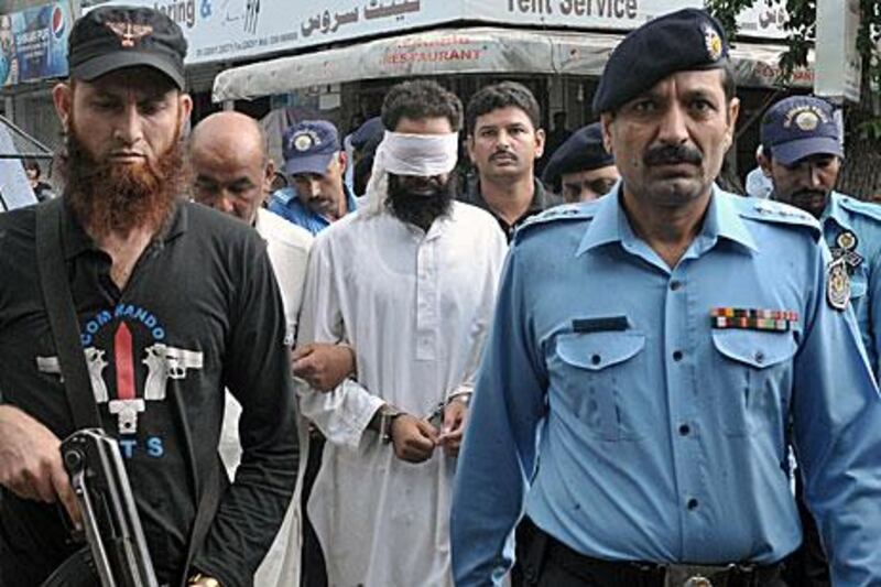 Pakistani police escort Hafiz Mohammed Khalid Chishti into an Islamabad court today.