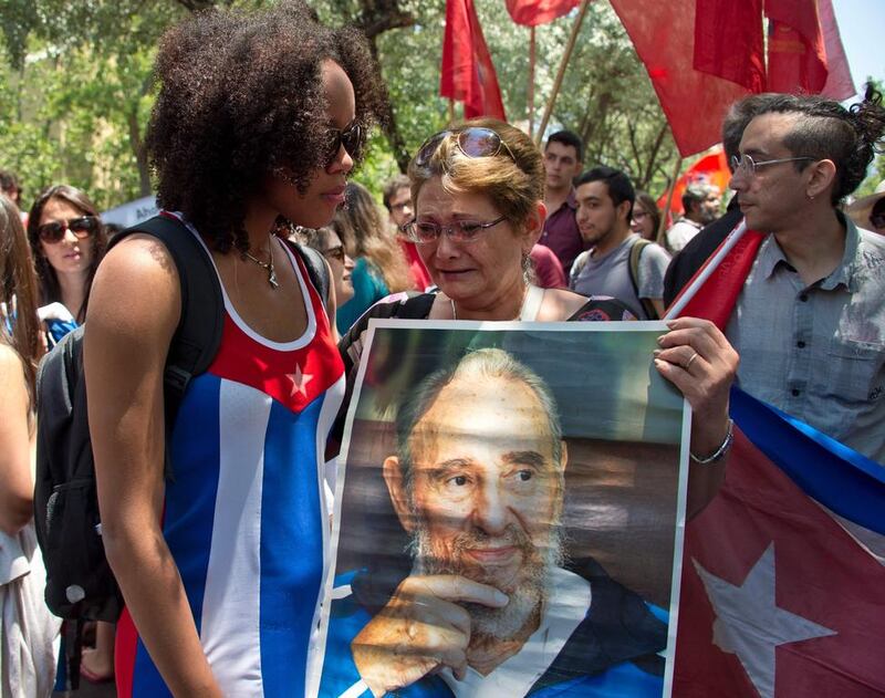Women cry as they hold a poster of Cuba's historic revolutionary leader Fidel Castro outside the Cuban embassy in Santiago on November 26, 2016, the day after he died aged 90.  Martin Bernetti / AFP