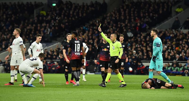 Referee Cuneyt Cakir shows a yellow card to Tottenham defender Ben Davies for his foul on Konrad Laimer that led to the penalty. AFP