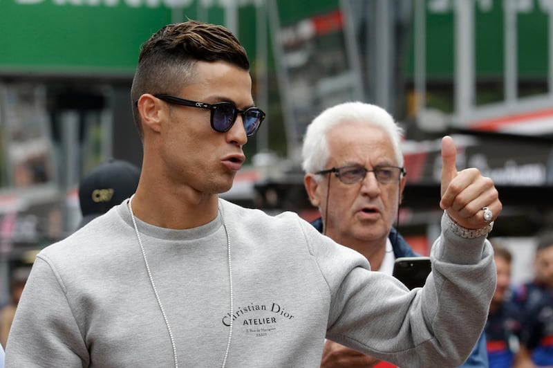 Cristiano Ronaldo applauds fans at the pit line ahead of the second practice session at the Monaco racetrack, in Monaco, Thursday, May 23, 2019. The Formula one race will be held on Sunday. (AP Photo/Luca Bruno)