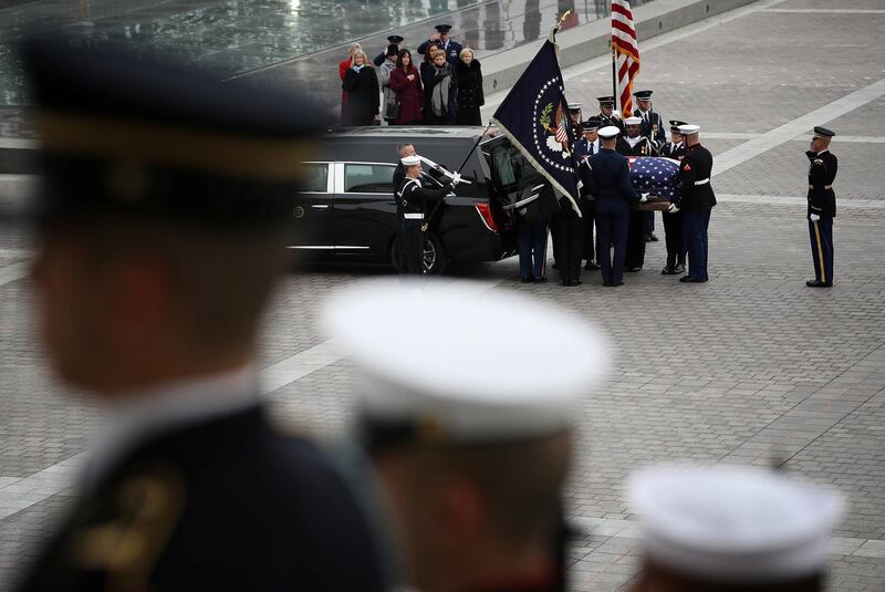 A US military honor guard team places the casket into a hearse. Reuters