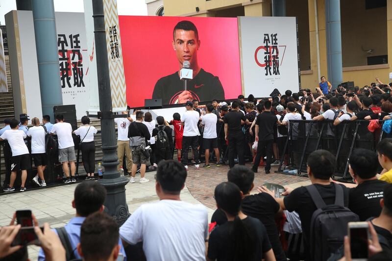Fans watch a large screen showing Ronaldo. EPA