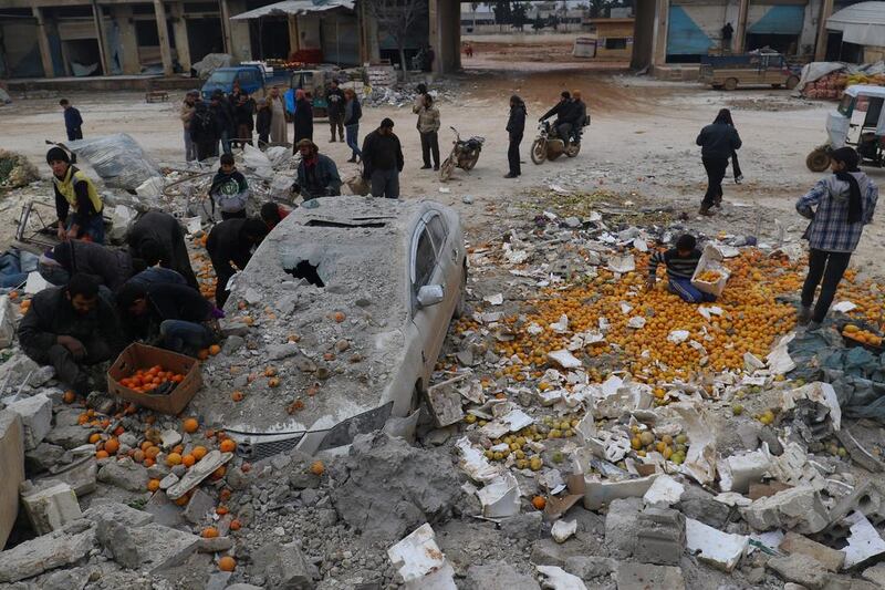 People collect scattered oranges amidst rubble after an airstrike on a market in the rebel-held city of Maarrat Misrin in Syria's Idlib province on January 14, 2017. Ammar Abdullah/Reuters
