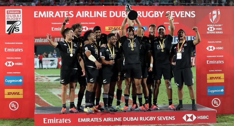 New Zealand's players celebrate with the trophy of the Men's Sevens World Rugby Dubai Series Cup after the Final match between USA an New Zealand on December 01, 2018. / AFP / KARIM SAHIB
