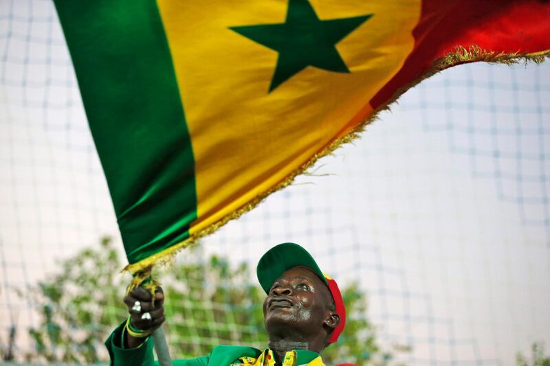 A fan waves the national flag during training session. AP Photo