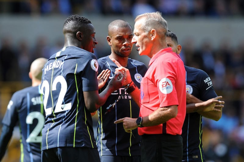 Referee Martin Atkinson talks with Manchester City's Benjamin Mendy, left, and Fernandinho. AP Photo