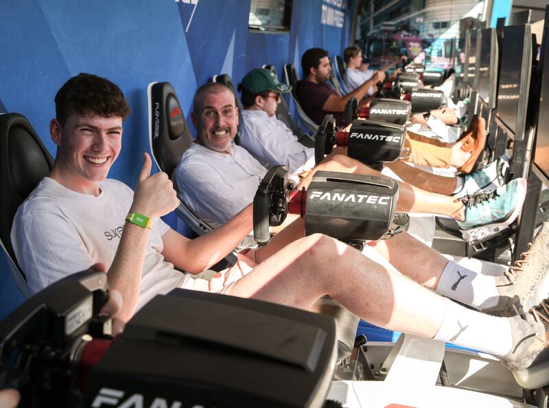 Motor racing fans try driving simulators in the F1 fan zone 