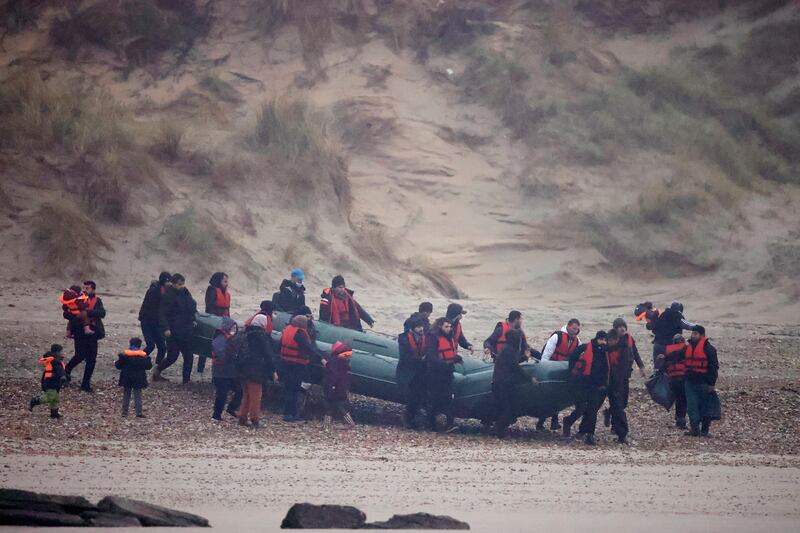 An inflatable dinghy similar to the one which deflated in the English Channel, resulting in the death of 27 people, is carried to the French coast. Reuters