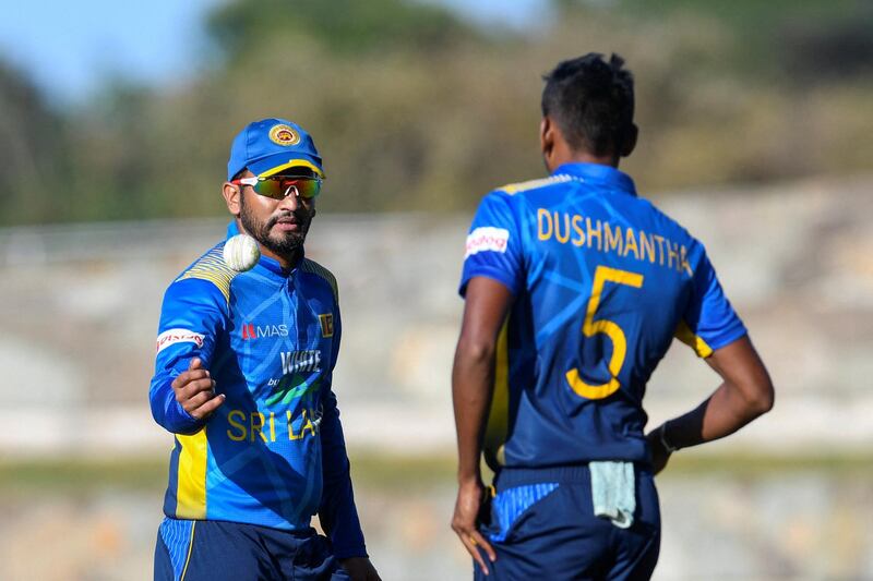 Dimuth Karunaratne (L) passes the ball to Dushmantha Chameera (R) of Sri Lanka during the 1st ODI match between West Indies and Sri Lanka at Vivian Richards Cricket Stadium in North Sound, Antigua and Barbuda, on March 10, 2021. (Photo by Randy Brooks / AFP)