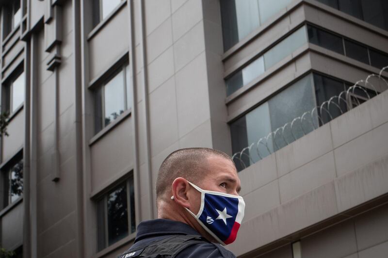 A police officer, wearing a face mask with the colours of the Texas flag, stands guard outside China’s Consulate after Chinese employees left the building. Reuters