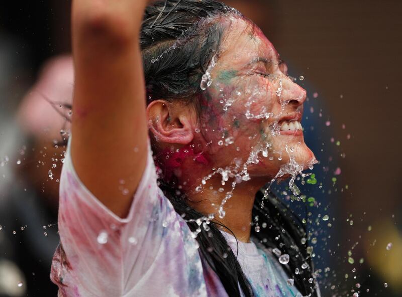 A Nepalese woman gets drenched in water as she celebrates Holi festival in Kathmandu, Nepal. Despite authorities urging people to celebrate the festival indoors only in view of Covid-19, thousands were celebrating outdoors in the capital. AP Photo