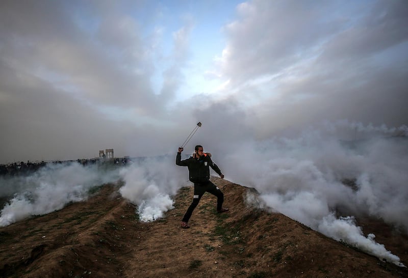 A Palestinian protester throws stones with a slingshot during clashes after Friday protests near the border between Israel and the Gaza Strip. EPA