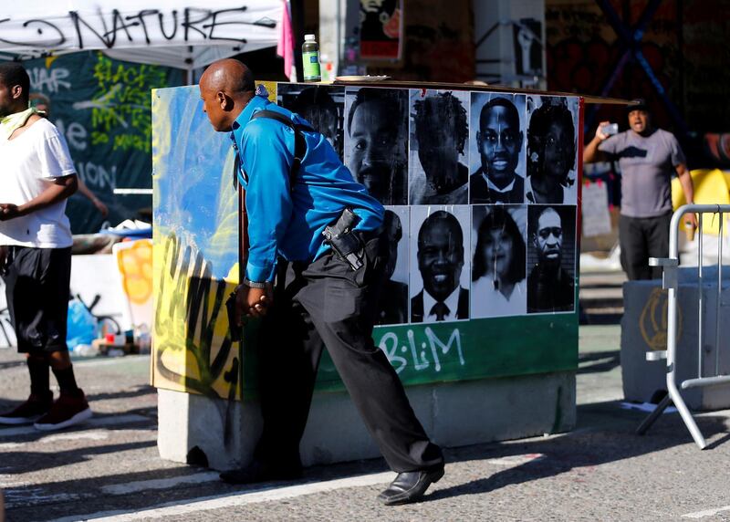 A protester stands behind a barricade holding a handgun during a dispute with another armed man that resolved with no shots fired at the CHOP area (Capitol Hill Occupied Protest), as people continue to occupy space and protest against racial inequality in the aftermath of the death in Minneapolis police custody of George Floyd, in Seattle, Washington, U.S. June 26, 2020. REUTERS/Lindsey Wasson     TPX IMAGES OF THE DAY