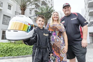 Zac Stimpson, 9, with his parents, Nicola and Paul. After his school banned homework, the year 5 pupil has spent his spare time at the racetrack in the hopes of becoming a Formula 1 driver. Antonie Robertson / The National