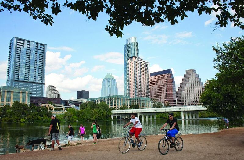 Cyclists on the Lady Bird Lake trail, with Austin’s downtown skyline in the background. The city ditches cars in favour of other transport. Julia Robinson / Reuters