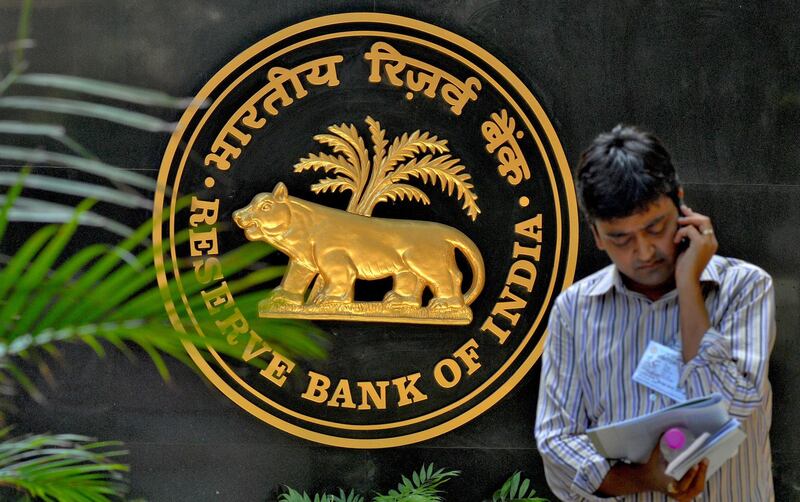 epa07223162 (FILE) - An Indian journalist speaking on the phone stands near the logo of the Reserve Bank of India (RBI) in Mumbai, India, 20 April 2010 (resissued 11 December 2018). According to media reports, the Indian rupee fell 1.2 percent against the US dollar on 11 December 2018, a day after the resignation of the country's central bank governor Urjit Patel.  EPA/DIVYAKANT SOLANKI *** Local Caption *** 51737330