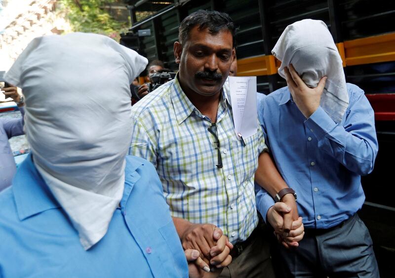 An official of India's Central Bureau of Investigation (CBI) escorts men suspected of steering fraudulent loans to companies linked to billionaire jeweller Nirav Modi outside a court in Mumbai, India, March 5, 2018. REUTERS/Danish Siddiqui