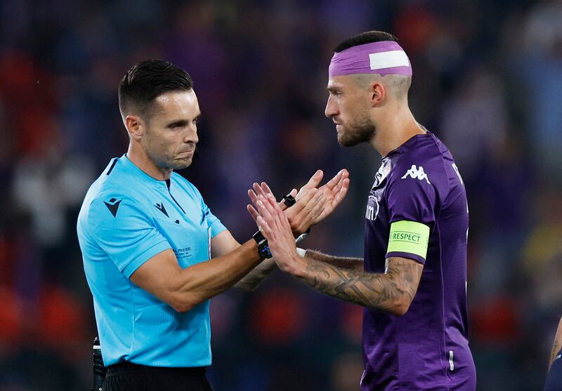 Fiorentina's Cristiano Biraghi speaks to referee Carlos Del Cerro with his head bandaged after he was hit by an object thrown by a West Ham fan. Reuters