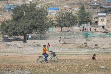 A boy carries an Afghanistan national flag as he rides his bicycle on Independence Day in Kabul, Afghanistan. EPA