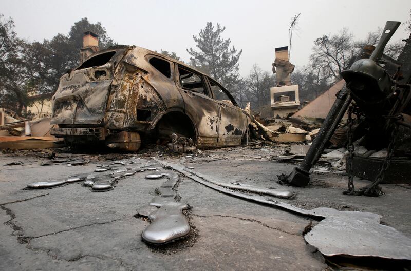 Rivers of melted metal flow from a vehicle parked at a home that was destroyed by a wildfire near Napa, Califoria. Rich Pedroncelli / AP Photo