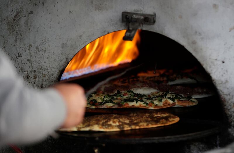 Traditional flatbread sprinkled with cheese and leafy vegetables. AFP