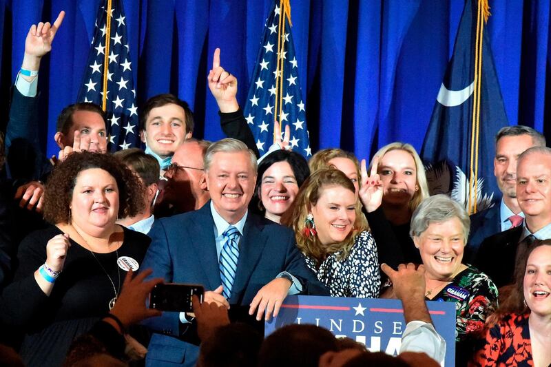 Supporters pose with U.S. Sen. Lindsey Graham, center, following his victory speech after winning another term in office, in Columbia, S.C. AP Photo