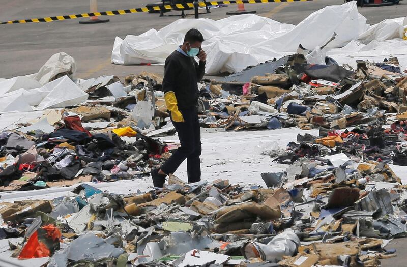 An investigator walks amid debris of the stricken aircraft. AP Photo