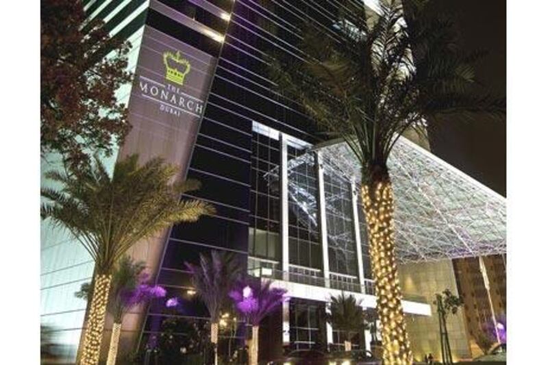 Lights shine on The Monarch Dubai's exterior at night.