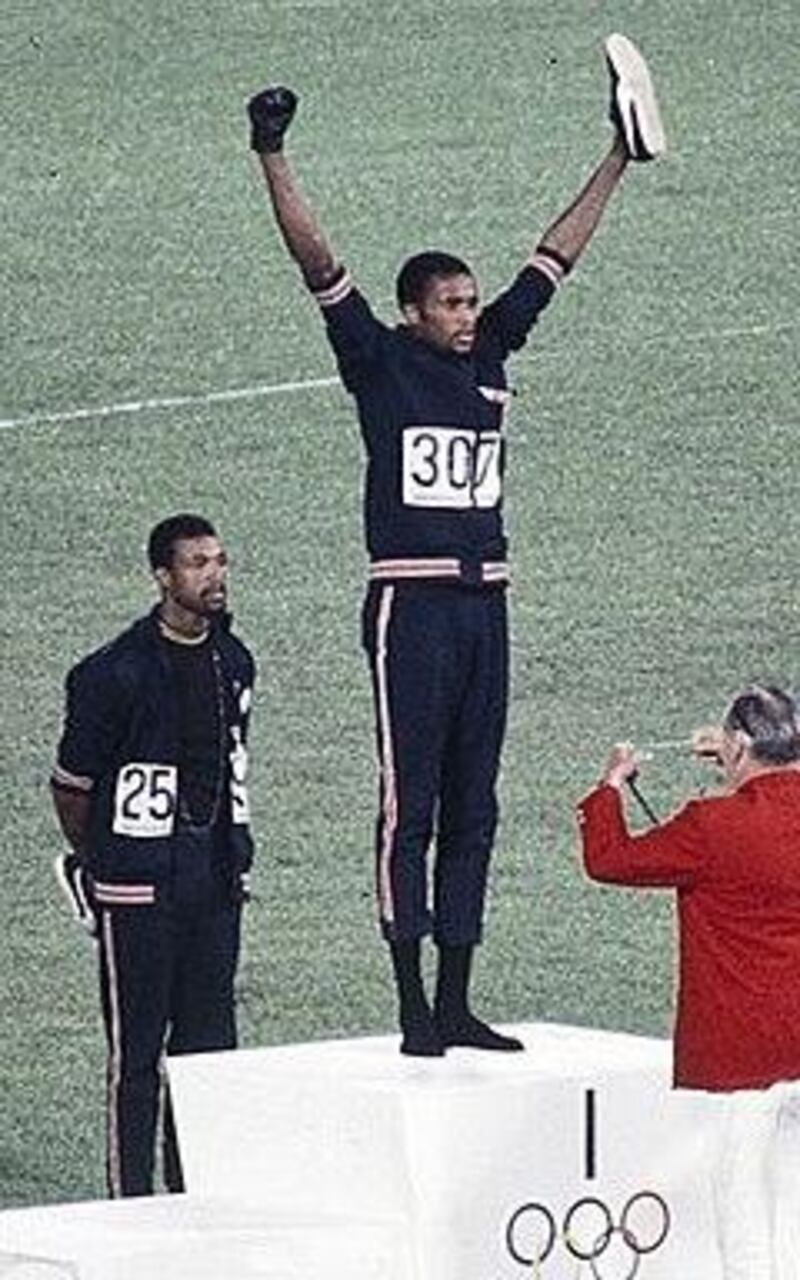 Clutching a single Puma Suede shoe, Tommie Smith of America  collects his gold medal at the 1968 Mexico Olympics. Courtesy Peter Norman