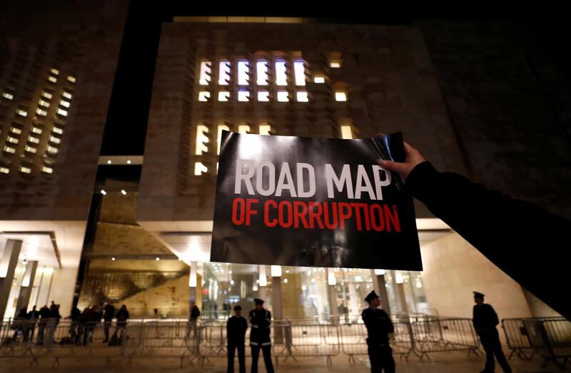 A demonstrator holds a sign during a protest outside the Parliament. Reuters