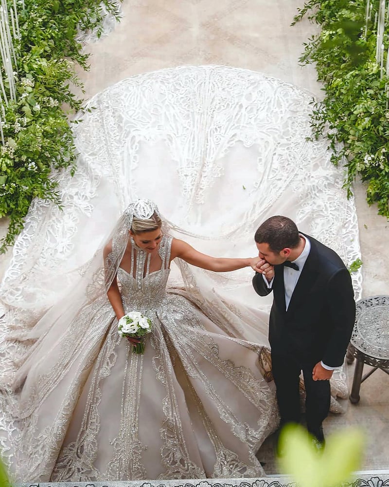 Saab Jr kisses his bride's hand at the ceremony.