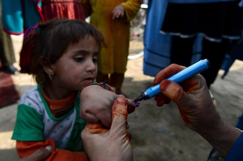 Afghan female health workers mark a child’s finger on February 24, 2014, after administering polio drops outside her house in Jalalabad in Nangarhar province. Wakil Kohsar / AFP photo