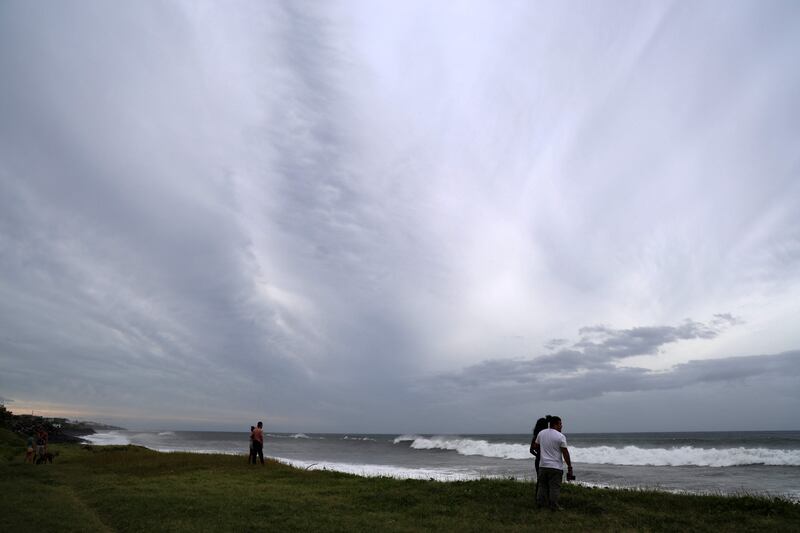 People watch the high waves in Sainte-Anne. AFP