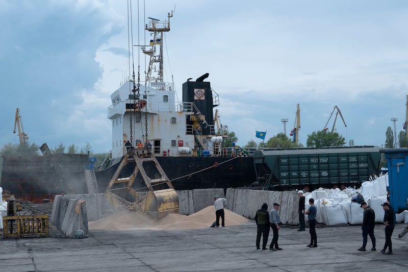 Workers load grain at a port in Izmail, Ukraine. AP