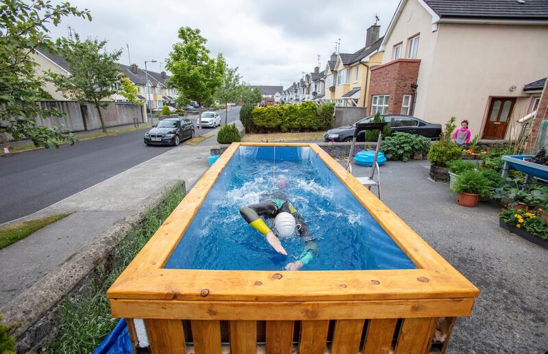 Irish Paralympic hopeful Leo Hynes, who is legally blind, trains in his home-made training pool in his front garden at home in Tuam, Co Galway, west Ireland, on June 18, 2020. - In his suburban driveway in the west of Ireland, blind triathlete Leo Hynes clambers into a box of water, straps himself to a bungee cord and starts to swim -- going nowhere, but going fast. During coronavirus lockdown, the aspiring paralympian has been unable to train as usual for the now-delayed Tokyo games. Instead he has been finessing his breaststroke in a homemade "treadmill pool" where he is held in place by elastic cords. (Photo by Paul Faith / AFP) / TO GO WITH AFP STORY BY JOE STENSON