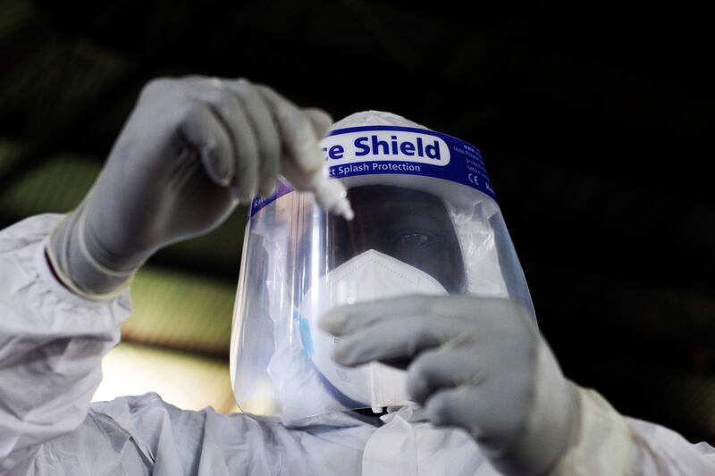 A health official takes a sample for tests at a private Covid-19 testing centre in Harare. AP 