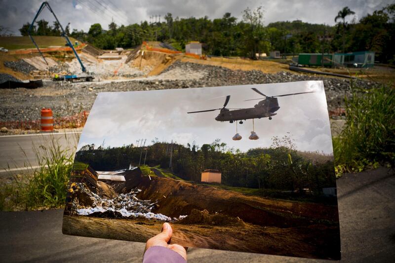 A printed photo taken on October 17, 2017 showing a US army helicopter transporting material to repair the Guajataca Dam. Repairs continue today.