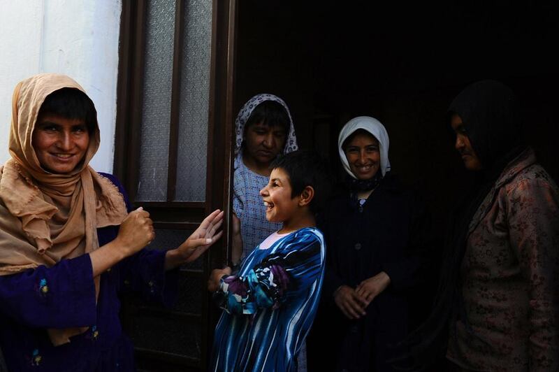 Clinic patients talk and laugh as they stand in the doorway to the female section of the only mental health rehabilitation centre in the city of Herat.