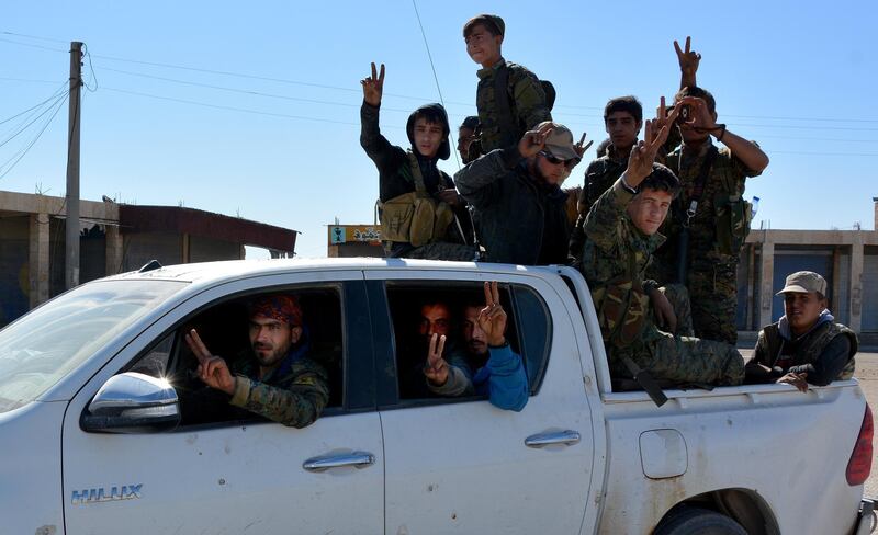 epa06275215 Fighters from Syrian Democratic Forces (SDF) flash the victory sign as they drive at the northern entrance of Al-Raqqa, Syria, 18 October 2017 (issued 19 October 2017). The Al-Na'im roundabout also known as the 'Roundabout of Hell', located in the center of the city of Al-Raqqa, has been the last to be liberated by US backed Syrian forces from the grip of the organization of the so-called Islamic State (IS, ISIS or ISIL). The roundabout was used by ISIS extremists to perform public executions, beheadings and crucifixions during their three-year rule of the city.  EPA/YOUSSEF RABIH YOUSSEF