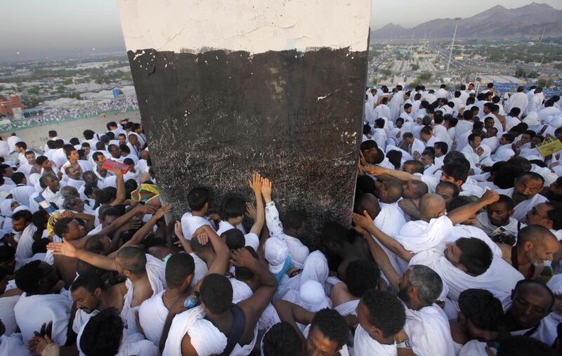 Muslim pilgrims pray on a rocky hill called the Mountain of Mercy, some touching a marker at its peak, on the Plain of Arafat, near the holy city of Mecca, Saudi Arabia. AP Photo/Amr Nabil