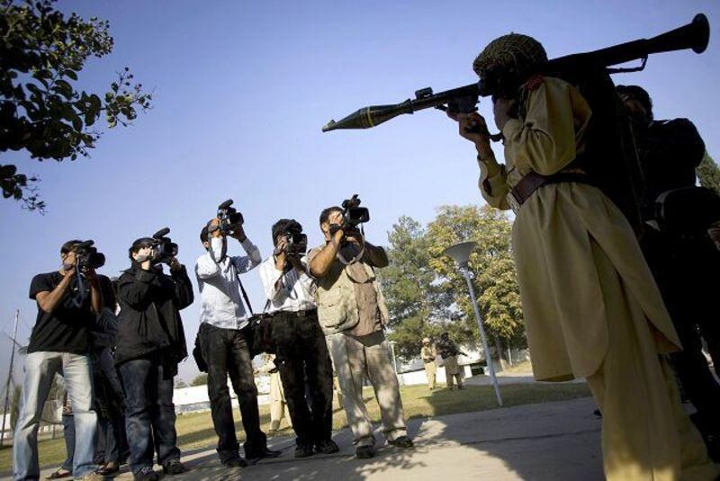 Pakistani TV cameramen are seen next to a soldier of Pakistan's army holding a Rocket Propelled Grenade near Loisam town in the Bajur tribal region.
