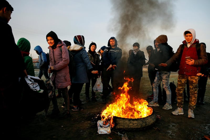 Migrants gather around a fire as they wait to cross the Evros river to reach Greece, near Doyran Village, near the Turkish border city of Edirne, Turkey. Reuters