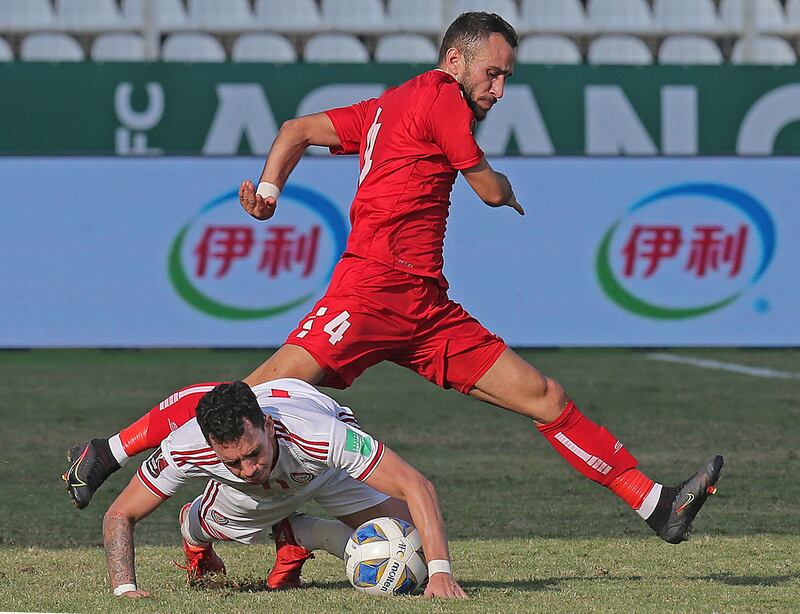 UAE forward Caio Canedo goes down under pressure from Lebanon's Abbas Assi. AFP