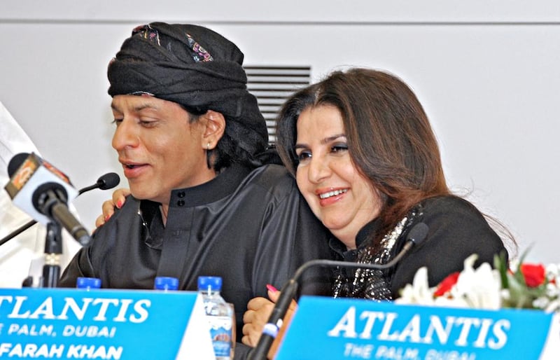 Bollywood director Farah Khan gives actor Shah Rukh Khan, left, a hug during a news conference at the Atlantis Hotel on The Palm Jumeriah this week. Jeff Topping for The National