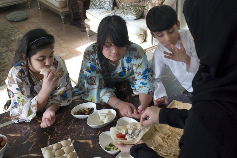 Noura Al Khoori and her children eat nabulsi and chaami cheeses at their Abu Dhabi home. Delores Johnson / The National